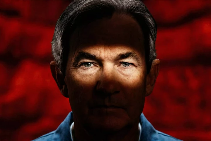 Jerome Powell con fondo rojo.